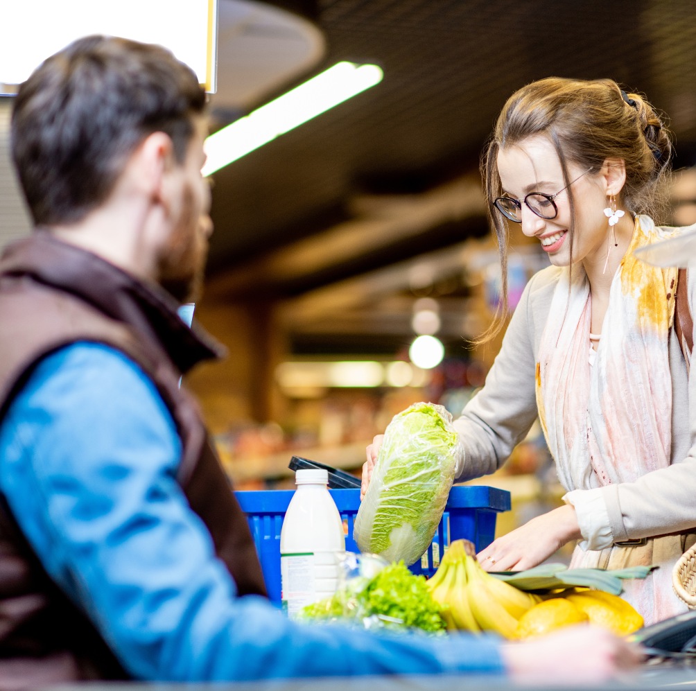 Une femme passant à la caisse d'un supermarché